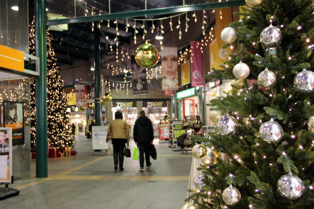 Indendørs shoppinggade med juletræer